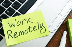 "Work Remotely" post-it note stuck to a laptop