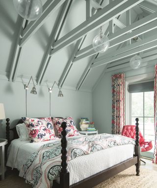 An example of how to plan bedroom lighting showing a large wooden bed with floral and white bedding in front of two functional wall lights
