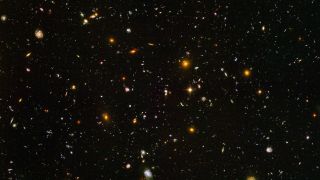 The vast blackness of space is filled with little points of light that are galaxies.