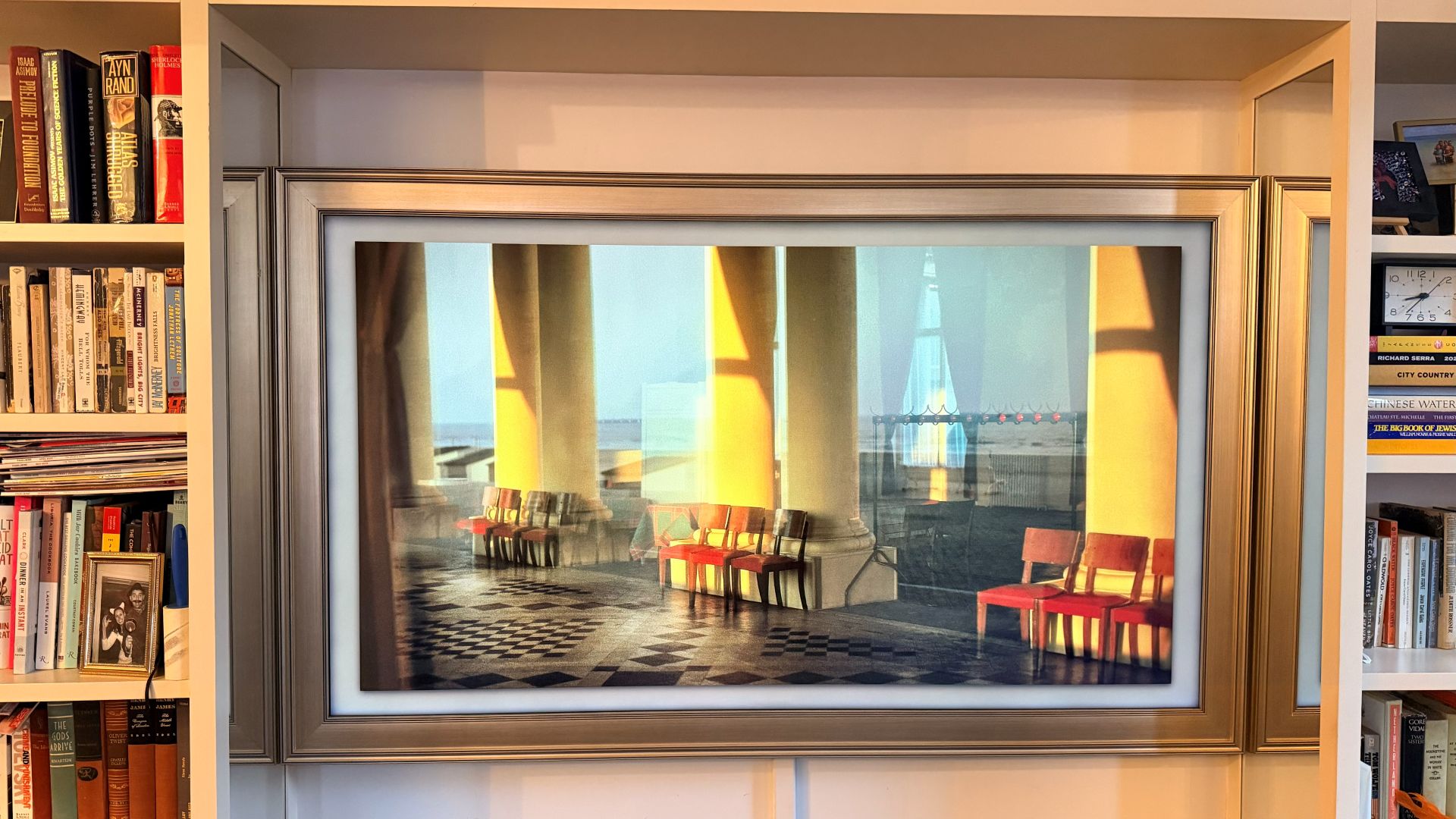 Samsung The Frame showing image of empty room with red chairs