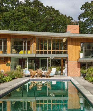 A contemporary self-build home with large glazing and a reflective swimming pool in front