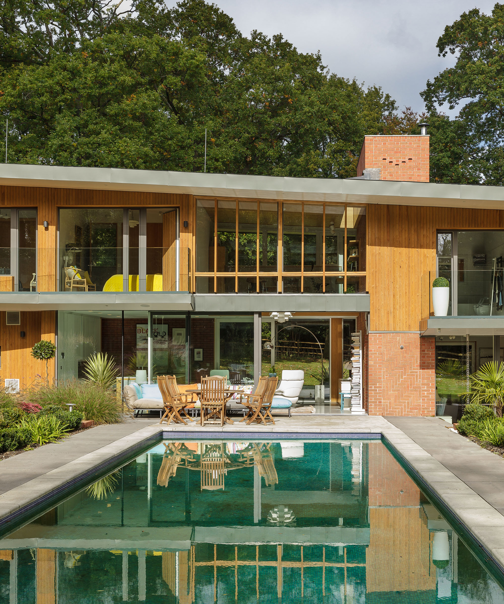 A contemporary self-build home with large glazing and a reflective swimming pool in front