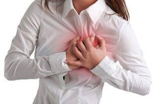 A woman grabs her chest in pain.