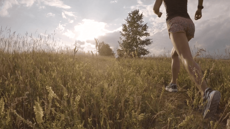 cinemagraph of a female runner in a field of long grass