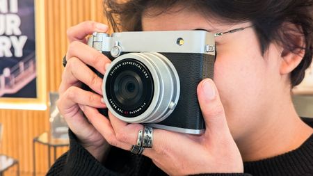 A person holding a Fujifilm GFX100RF camera