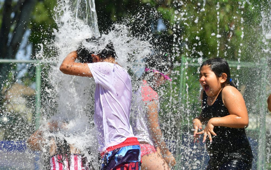 Kids play in the water to try and cool off in Alhambra, California.