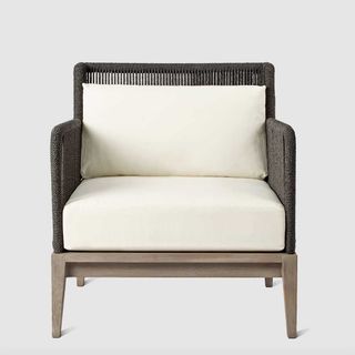 garden armchair with cream cushions and dark rope woven frame to support the quiet luxury garden trend