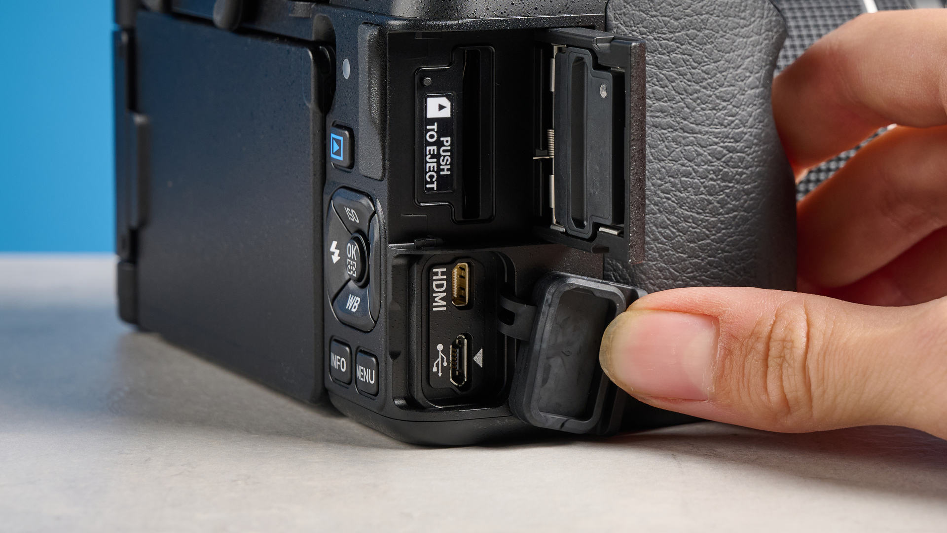 Pentax KF DSLR camera photographed on a blue background