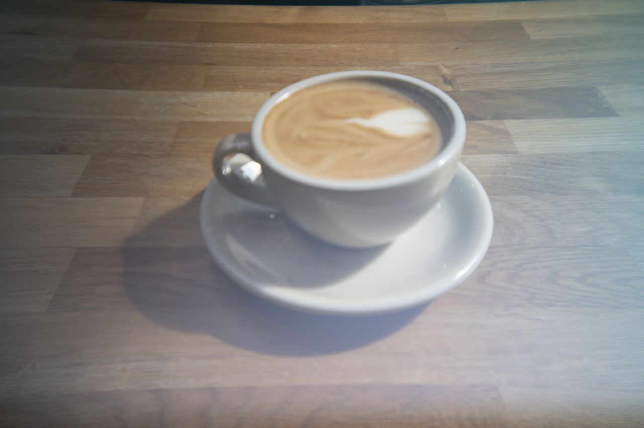 A cup of coffee in a cafe on a wooden surface