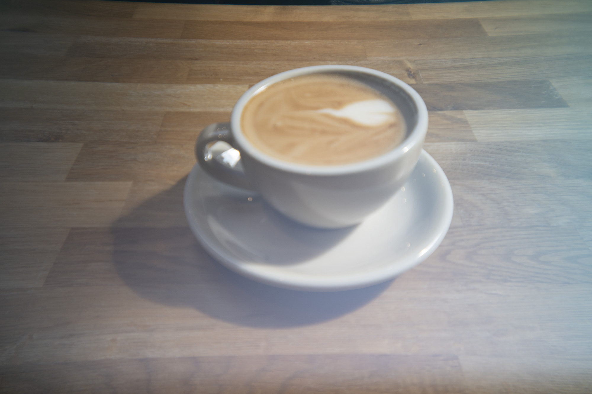 A cup of coffee in a cafe on a wooden surface