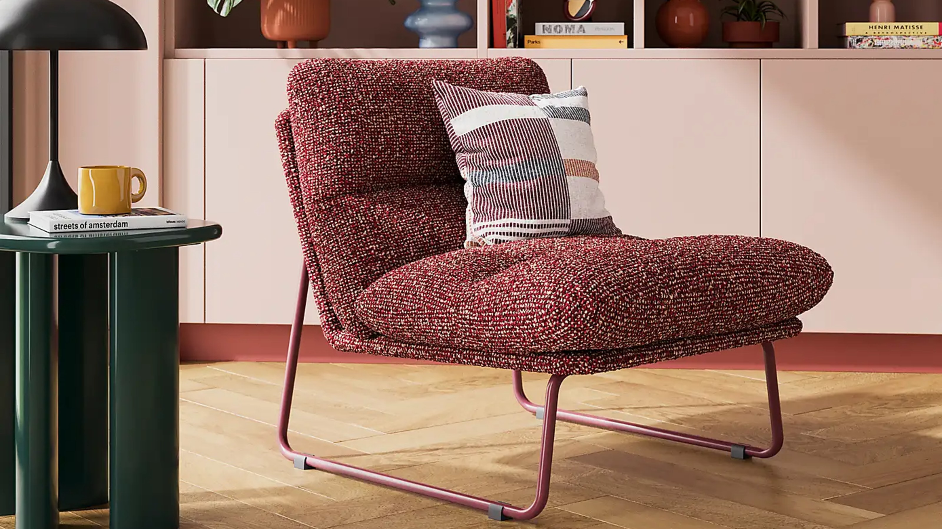 Dunelm Elements Finn Textured Sherpa Occasional Armchair in a living room with a glossy green side table and pink built-in bookcases behind
