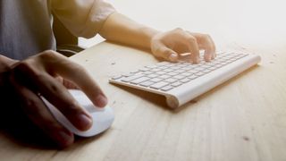 Best wireless keyboard and mouse: image shows person using wireless keyboard and mouse on desk