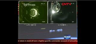 Chinese TV shows the Tiangong 1 module docking with the Shenzhou 8 spacecraft Nov. 2, 2011.