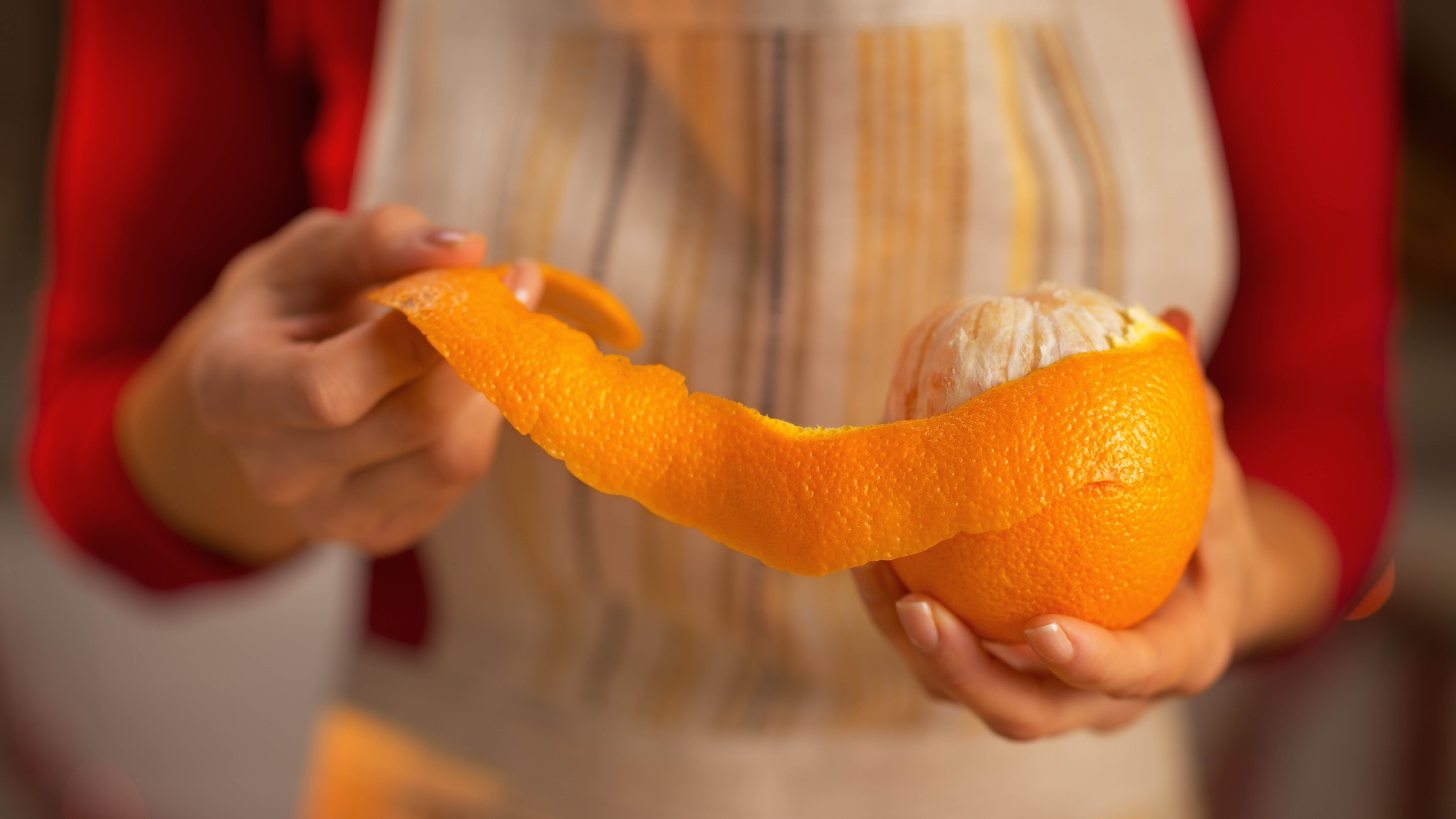 Someone holding an orange and peeling the rind away