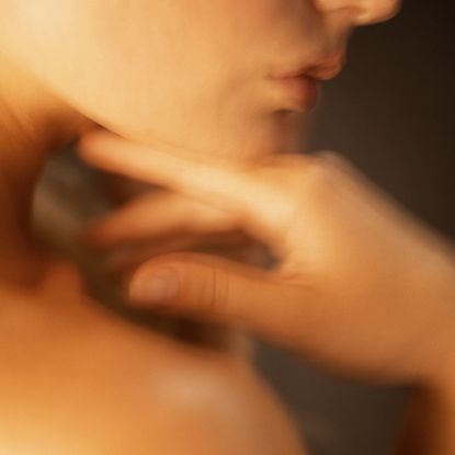 model giving herself a lymphatic drainage massage