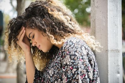 PMS symptoms: A Mixed Race woman rubbing forehead