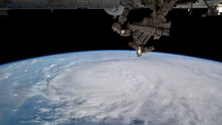 a large storm can be seen beneath the international space station