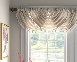 White draping valance on window with tassel fringe