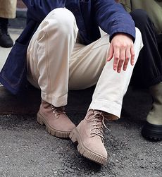 A man sitting on a curb wearing Timberland boots