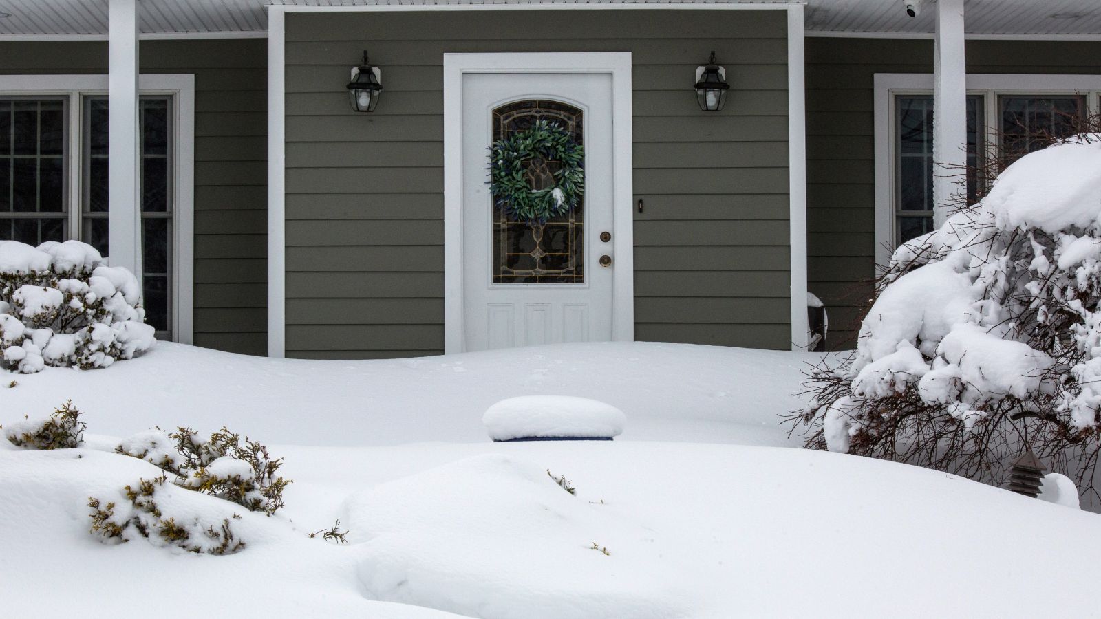 Front of house with yard full of snow