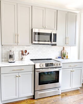 Microwave built into gray cabinets above stove