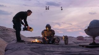 A behind the scenes shot of Grogu and Din Djarin filming The Mandalorian in The Volume set