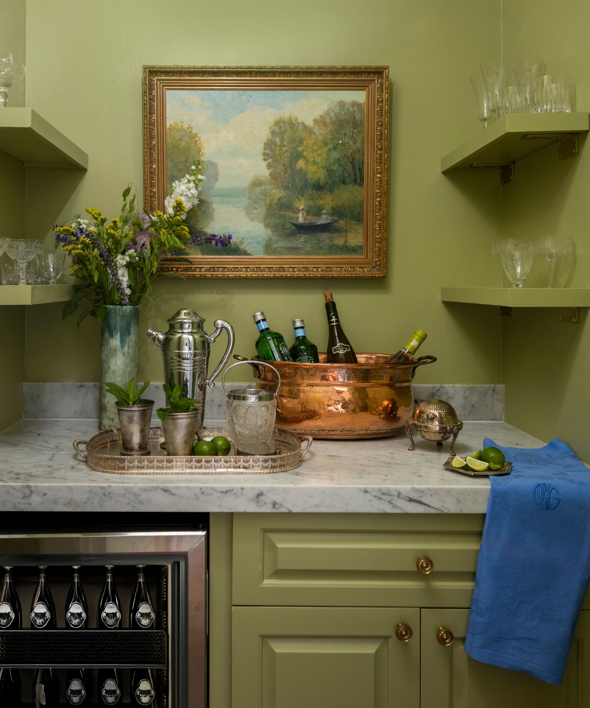 Home bar painted green with a antique copper cauldron used as an ice cooler at The Marlene hotel