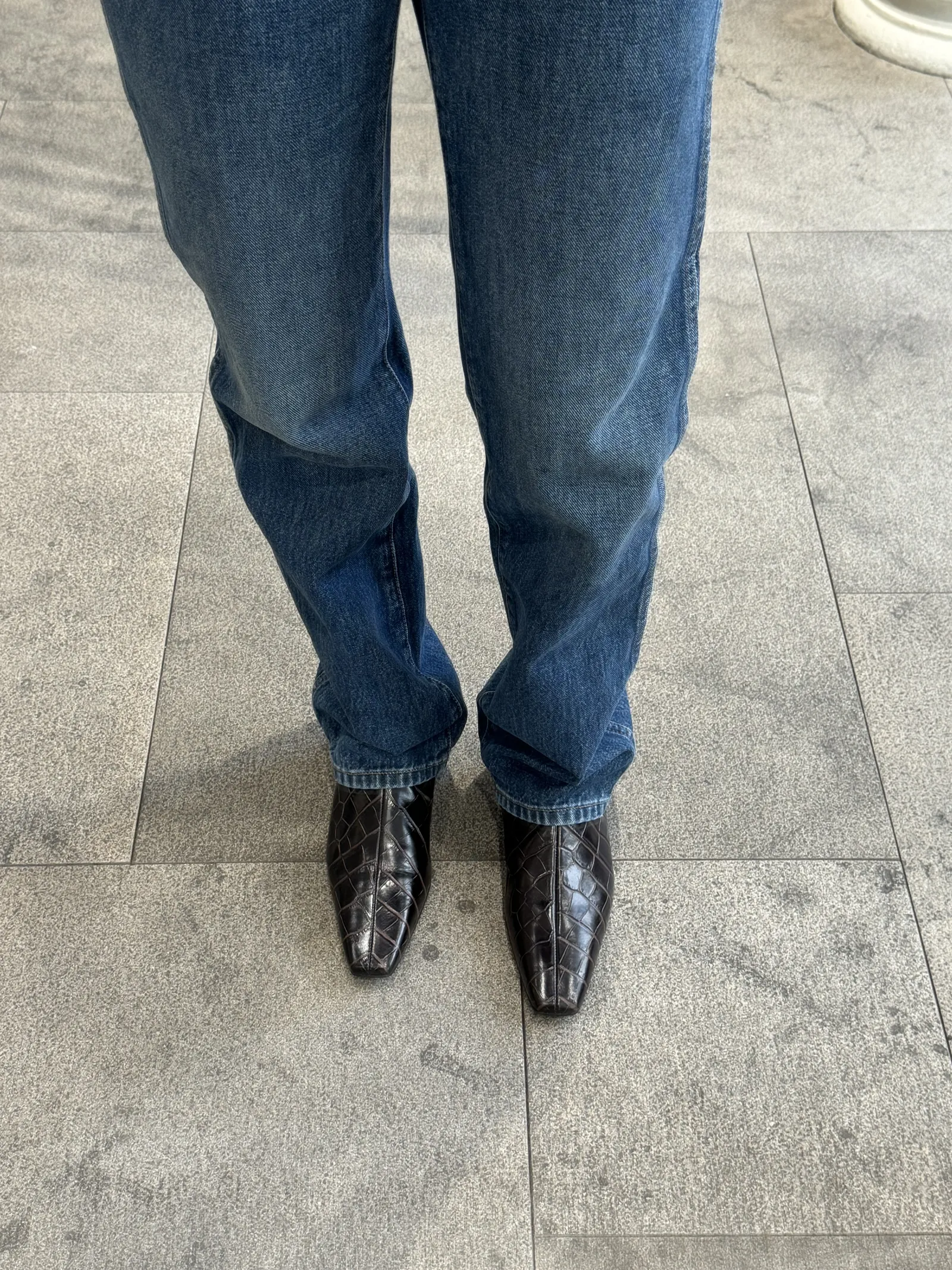 a woman wearing croc embossed boots