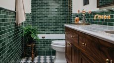 a half tiled green bathroom with a checkerboard floor