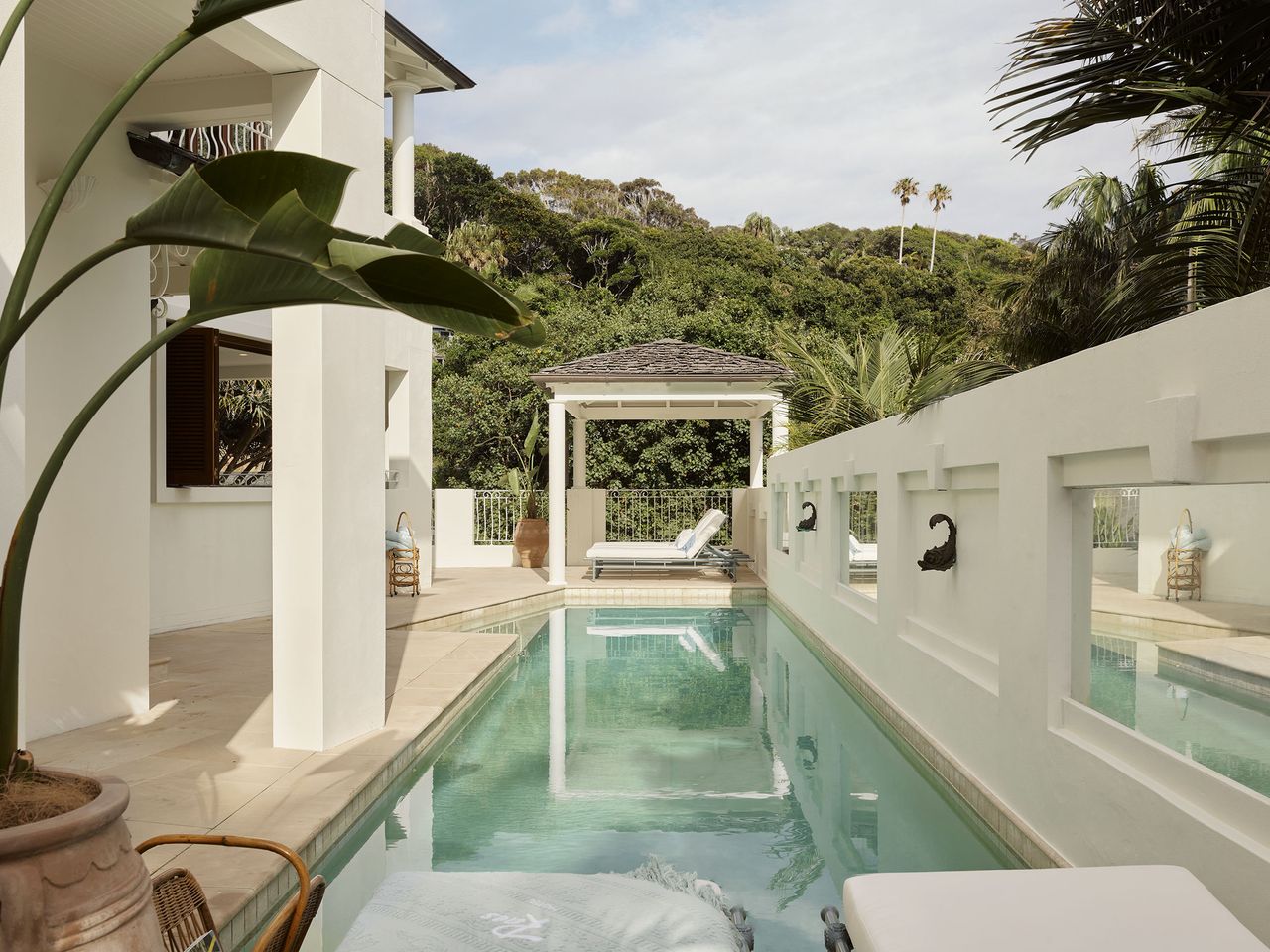 The communal pool area with lounge chairs overlooked by the bedroom balconies