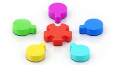 Five pieces of a puzzle arranged around a bigger piece in the center.