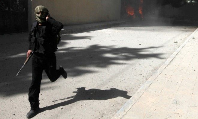 An Al Nusra fighter runs as the group&amp;#039;s base is shelled in Raqqa province on March 14.