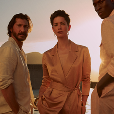 Two men and one woman standing close together wearing cream linen shirts and a suede suit jacket tied at the waist from Banana Republic. 