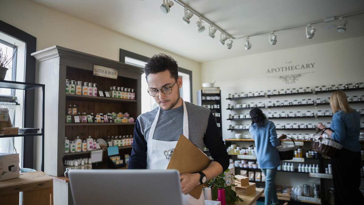 A man working at a laptop in a toiletries and wellbeing retailer