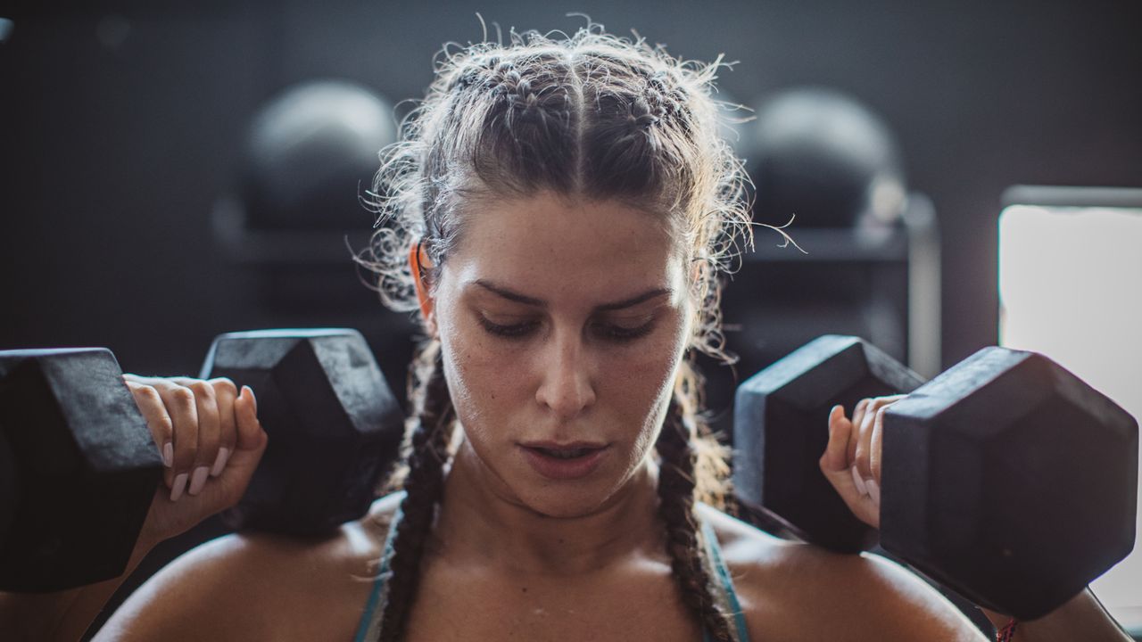 Woman lifting two dumbbells above her head