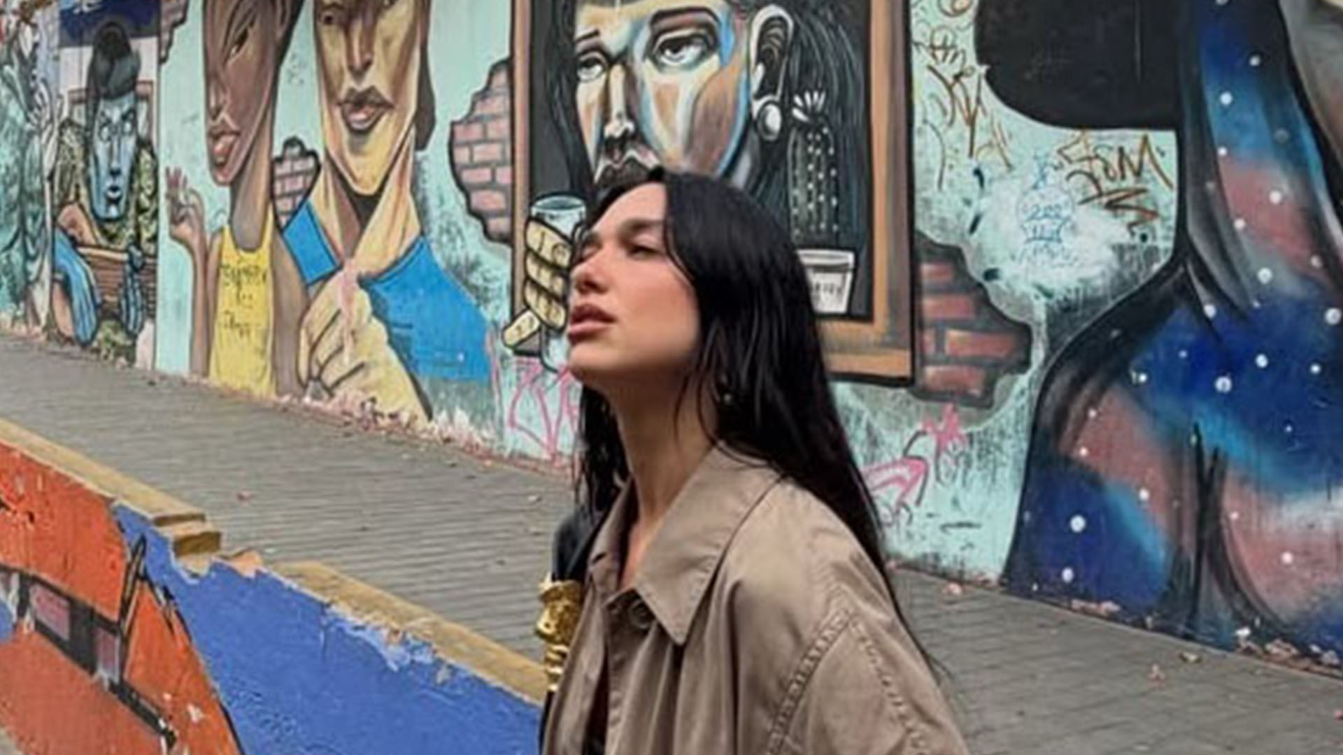 Dua lipa wearing a satin dress and trench coat