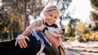 Woman hugging dog on walk