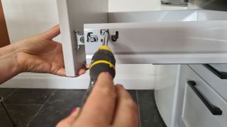 tightening screws on a kitchen drawer