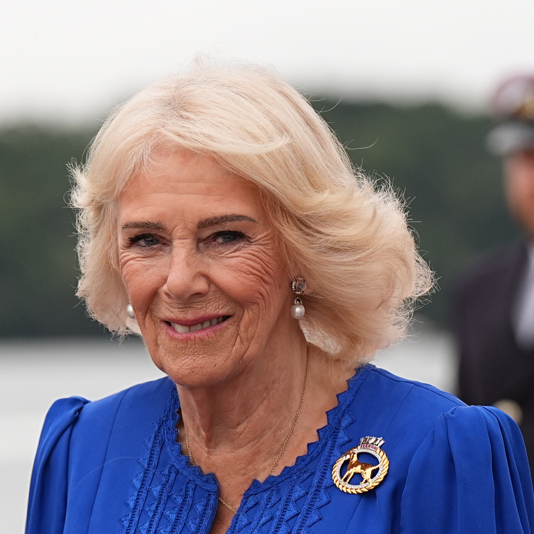 Queen Camilla wearing a blue dress and smiling