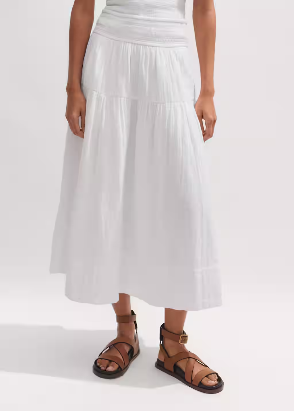 a model wearing a long white elastic waist skirt