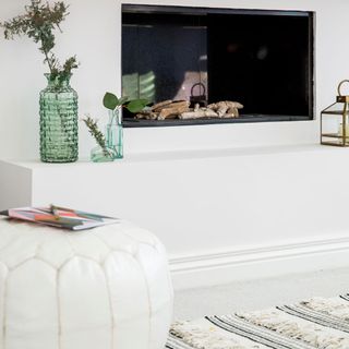 white room with fire place and flower vase
