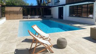 garden swimming pool outside home with patio area