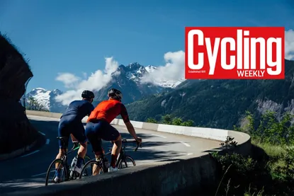 Two cyclists side by side riding up a mountain with Cycling Weekly logo