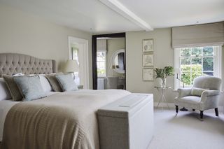 Light sage walls, grey ottoman, cream carpeted floor