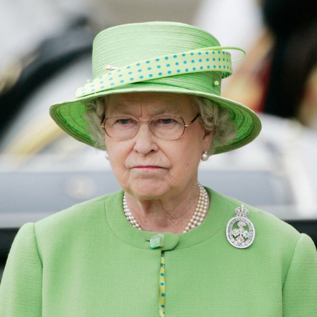 Queen Elizabeth II purses her mouth and looks annoyed while wearing a lime green coat dress and a matching hat in 2007