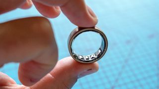 Amazfit Helio Ring held between a person's fingers