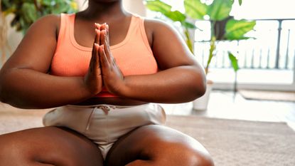How to decrease cortisol: A woman meditating 