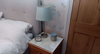 Bedside cabinet with wallpaper on top below a glass sheet