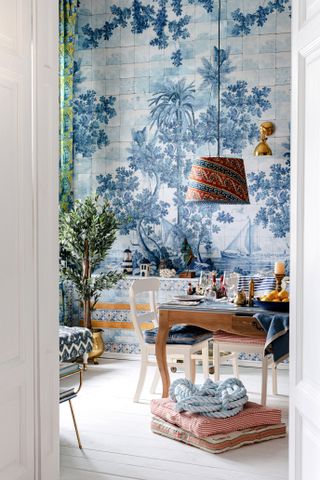 blue and white dining room with maximalist wallpaper and lamp over table