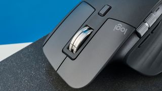 A photo of the Logitech MX Master 3S on a black slate against a blue background.